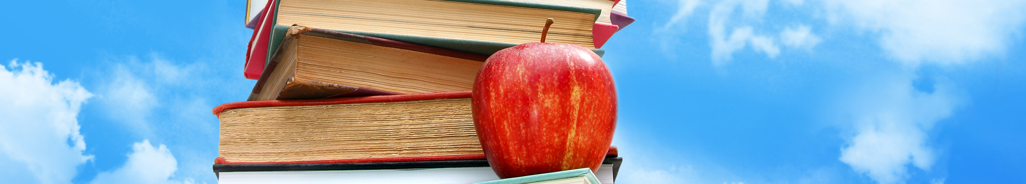 a red apple on a stack of books with a blue sky in the background