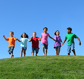 six kids running in the grass